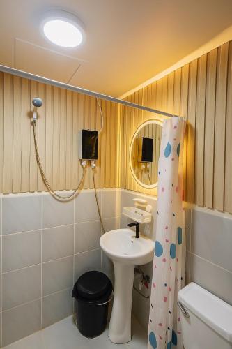 a bathroom with a sink and a shower curtain at Luxury poolview condo with pool access! in Suba