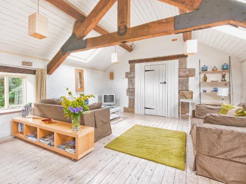 a living room with two couches and a table at Town End Barn in Warslow