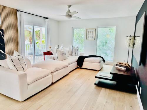 a living room with two white couches and a table at Siesta Key - Pet Friendly - Private Pool - Garage - Aylees Private Beach House in Siesta Key