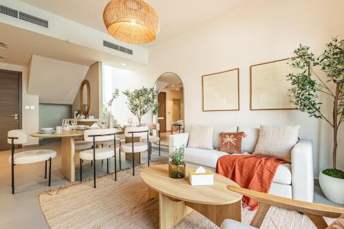 ein Wohnzimmer mit Sofa und Tisch in der Unterkunft Amazing Townhouse - Yas Island - 5 min to Formula 1, Ferrari World, Warner Bros, Sea World - Designer's Choice in Abu Dhabi