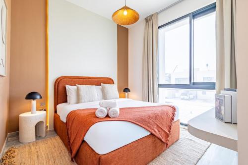 ein Schlafzimmer mit einem Bett mit zwei Handtüchern darauf in der Unterkunft Amazing Townhouse - Yas Island - 5 min to Formula 1, Ferrari World, Warner Bros, Sea World - Designer's Choice in Abu Dhabi