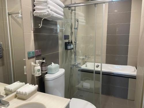 a bathroom with a shower and a toilet and a sink at Blue Sea and Sunny B&B in Toucheng