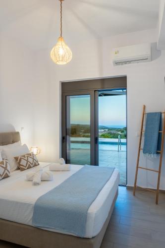 a bedroom with a bed and a view of the ocean at Villa Elaia Luxury Villa with Private Pool & Sea View in Sitia