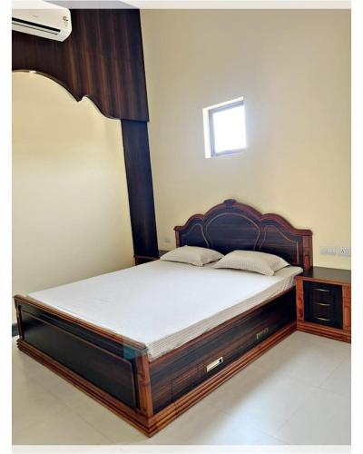 un letto con struttura in legno in una stanza di Villa Namkhey a Raichak