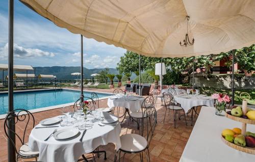 a restaurant with tables and chairs and a pool at Gorgeous Home In Rivodutri in Apoleggia