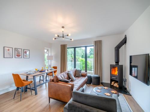 a living room with a couch and a fireplace at Ryseholme in Summer Bridge