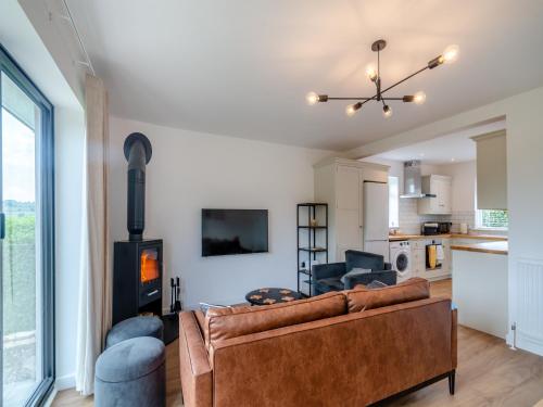 a living room with a couch and a fireplace at Ryseholme in Summer Bridge