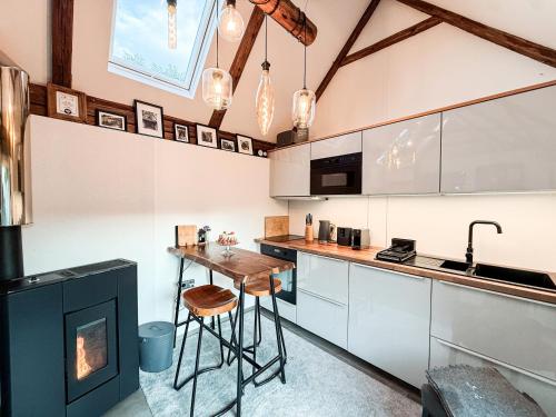 Una cocina con gabinetes blancos y una mesa de madera. en Chalet Sternenzauber, en Waasen