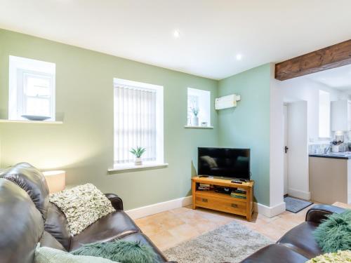 un soggiorno con un divano e una televisione di Riding Cottage - Uk37449 a Pateley Bridge