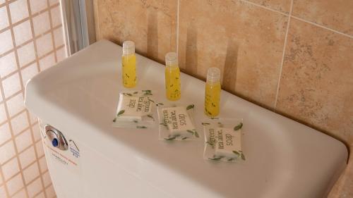 a white bath tub with three bottles on it at Hotel Marllou in Xalapa