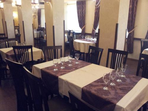 una sala da pranzo con due tavoli con bicchieri da vino di Hotel Intim a Rădăuţi