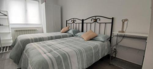 a bedroom with two beds with pillows on it at Apartamento acogedor en La Camocha-Gijón in Monte de Huerces