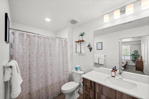 214 North Temple CondominiumModern Downtown 2BR 2BA with City Views Fire Pit Walk to Delta Center的浴室里有马桶、洗手池和镜子。