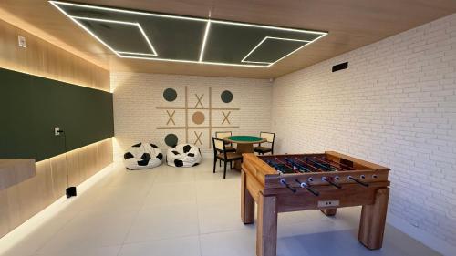 a room with a ping pong table and a table at Apartamento Pé na Areia in Ilhéus