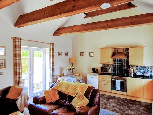 a living room with a couch and a kitchen at The Pottery in Horncastle