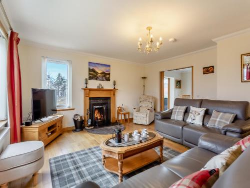 un salon avec un canapé et une cheminée dans l'établissement Bramble Cottage, à Gairloch