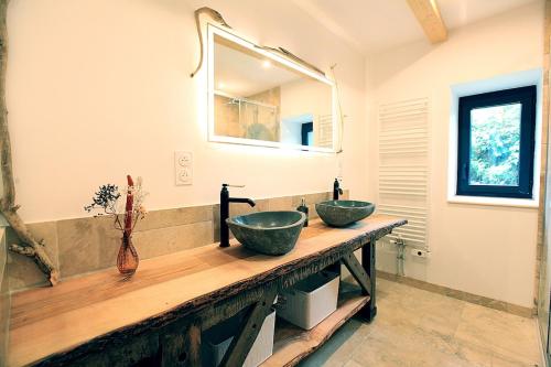 two sinks on a wooden counter in a bathroom at Le Petit Nid de Gioux in Rochefort-Montagne