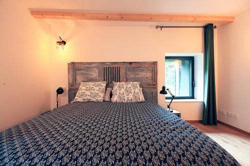 a bedroom with a large bed with a wooden headboard at Le Petit Nid de Gioux in Rochefort-Montagne