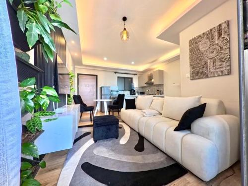 a living room with a white couch and a table at Modern Luxury 1BR in Nairobi