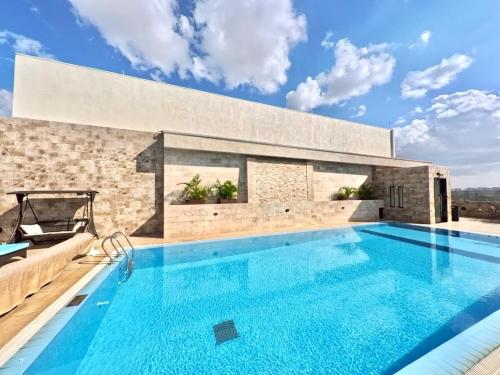 a swimming pool in front of a building with a brick wall at Modern Luxury 1BR in Nairobi