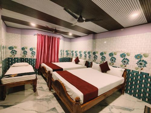 a bedroom with two beds in a room at THIRUNALLAR Udhayam Residency INN in Thirunallar