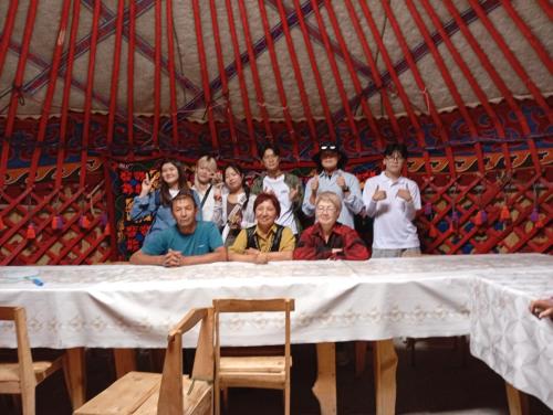 a group of people standing behind a table at Kf guest house 2 in Shabdan
