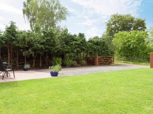 a garden with a fence and a grass yard at Walkers Lodge in Hampton Bishop