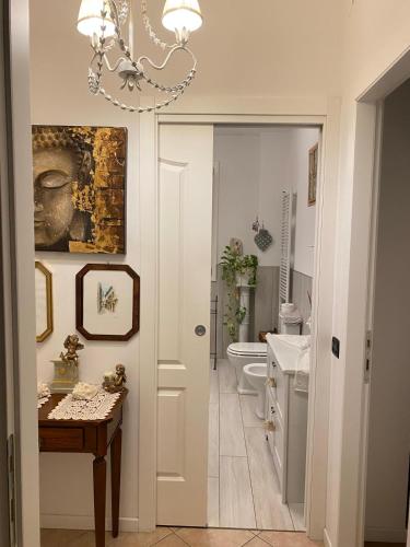 a bathroom with a chandelier and a sink and a toilet at SIDI & Bb in Casalecchio di Reno