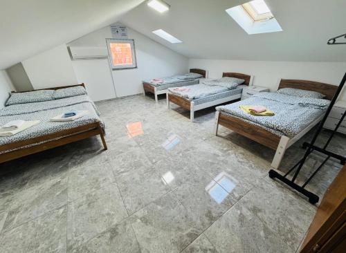 a room with three beds in a room at Dardania Hostel in Peje