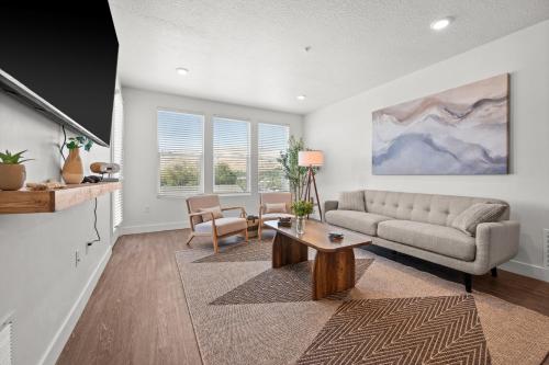 a living room with a couch and a table at Modern Downtown 2BR 2BA Near Delta Center with Fire Pit BBQ and City Views in Salt Lake City