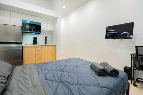 a bedroom with a bed and a refrigerator and a tv at Great apartment with parking in Montréal