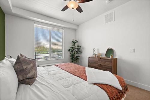 a bedroom with a bed and a ceiling fan at Modern Downtown 2BR 2BA Near Delta Center with Fire Pit BBQ and City Views in Salt Lake City