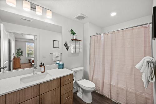 a bathroom with a toilet and a sink and a shower at Modern Downtown 2BR 2BA Near Delta Center with Fire Pit BBQ and City Views in Salt Lake City