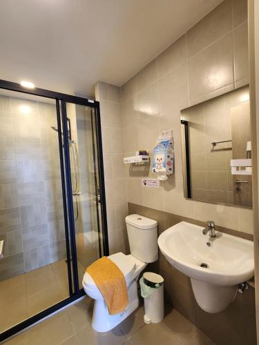 a bathroom with a toilet and a sink and a shower at Cozy Minimalist apartment in Kathu
