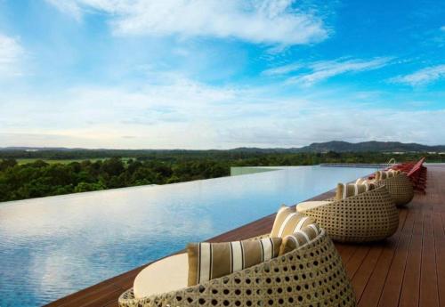 a deck with two lounge chairs and a swimming pool at Private Apartment Wyndham Panbil with Gym & Pool in Kangboi