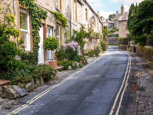 an empty street in a village with houses at Coach House Cottage in Buckden