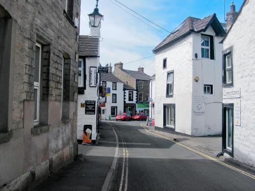 an empty street in a small town with buildings at Coach House Cottage in Buckden