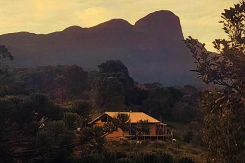 ein Haus mit einem Berg im Hintergrund in der Unterkunft Casa na Cachoeira das Fadas - Matutu, Aiuruoca - MG in Aiuruoca