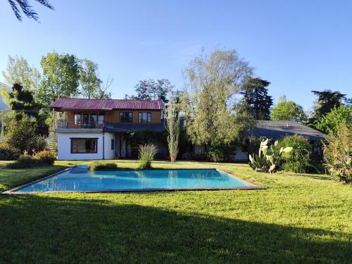 a house with a swimming pool in the yard at Hostal El Carmen de Pirque in Pirque