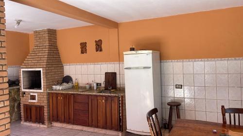 a kitchen with a white refrigerator in a room at Casa em São Sebastião refúgio do pontal in São Sebastião