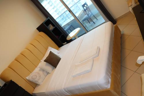 ein großes weißes Bett in einem Zimmer mit Fenster in der Unterkunft Panoramic Marina View in Dubai