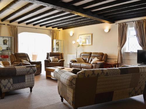 a large living room with couches and chairs at Green Acre Cottage in Kilgetty