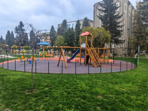 un patio de recreo en un parque con un tobogán en Mony Apartaments, en Roman