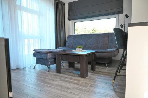 a living room with a couch and a table at Mini Kintų Perlas - Private Bungalow Complex in Kintai