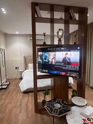 a living room with a large television in a bedroom at Quite and cozy studio in Riyadh