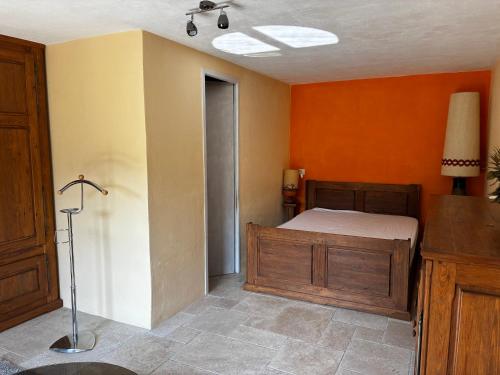 a bedroom with a bed and orange walls at Joli appartement avec superbe extérieur in Jausiers