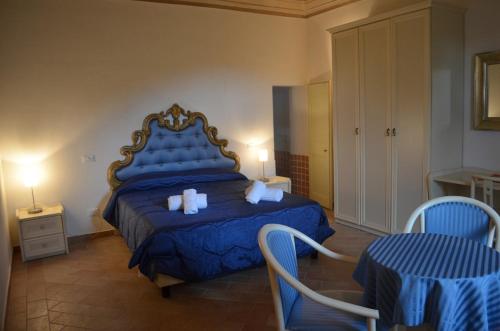 a bedroom with a blue bed and two chairs at Urbania, Arte e Natura in Urbania