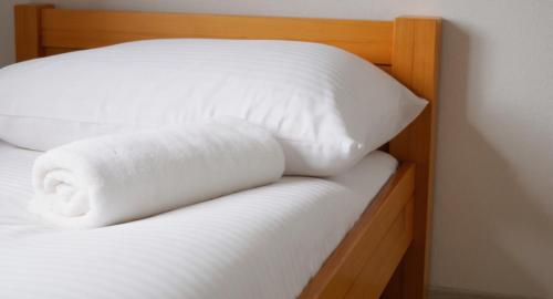 a bed with two white pillows on it at Jariabka Chalet Zrub Nízke Tatry in Jarabá