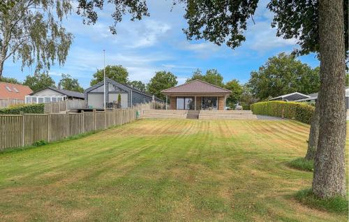 a yard with a fence and a house at Lovely Home In Sunds With House Sea View in Sunds