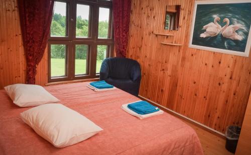 a bedroom with two beds and a chair and a window at Jöekalda Accommodation in Pulli